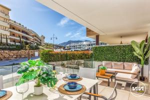 un patio avec tables et chaises sur un balcon dans l'établissement ViVi Homes - Apollo Luxury, Pool, Gym & Beach, à Fuengirola