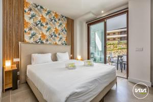 une chambre avec un grand lit blanc et un balcon dans l'établissement ViVi Homes - Apollo Luxury, Pool, Gym & Beach, à Fuengirola