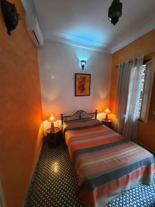 um quarto com uma cama com dois candeeiros em duas mesas em Riad Todra em Marraquexe