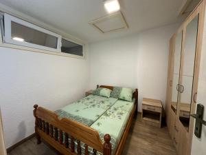 een kleine slaapkamer met een bed en een raam bij Urban Apartmens 5 in Jošanička Banja