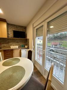 een keuken met een tafel en een groot raam bij Urban Apartmens 5 in Jošanička Banja