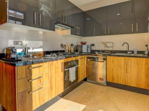 a kitchen with wooden cabinets and stainless steel appliances at Iris Agadir - Luxe - Piscine - 4 Px in Agadir