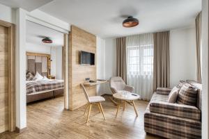 a hotel room with a bed and a couch at Hotel Hoferwirt - Neustift, Stubai in Neustift im Stubaital