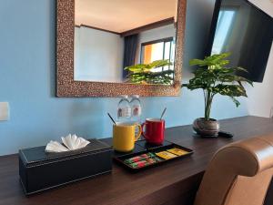 a desk with a mirror and a tray with drinks on it at Mido Selected Resort Pool Hotel in Pattaya