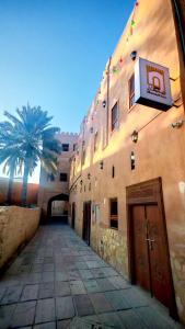 a building with two palm trees in front of it at Manazil Inn نزل المنازل in Nizwa