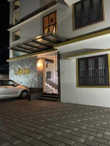 a car parked in front of a building at La Mer Inn in Kozhikode