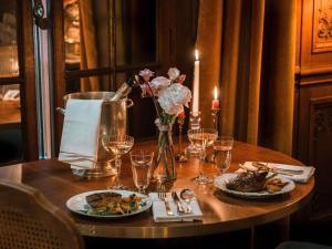 マフリエにあるHotel Novotel Domaine de Maffliers - Paris Val-d'Oiseの木製テーブル(皿盛りと花付)