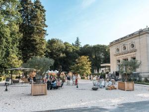 マフリエにあるHotel Novotel Domaine de Maffliers - Paris Val-d'Oiseの建物の前に椅子に座っている人々のグループ