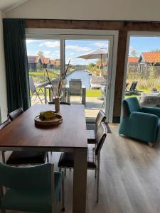 a dining room with a table and chairs and a large window at Lauwershuisje, Sauna, Harbour Lauwersmeer in Anjum +8 photos