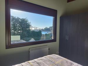 a bedroom with a large window with a view at Casa a pié de playa de Cariño Doniños in Ferrol +48 photos