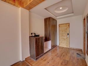 an empty room with wooden floors and a door at Omavya luxury hotel & cottage -with bonfire , apple orchid ,mountain view , parking in Vashisht +19 photos