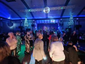 Eine Menschenmenge tanzt in einem Raum mit Weihnachtsbäumen in der Unterkunft Empress Boutique Hotel Suites in Mexborough