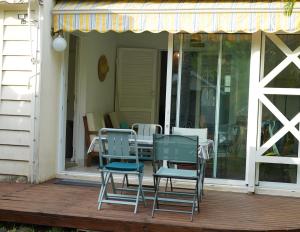 een patio met stoelen en een tafel op een veranda bij Dodo Coconut lagon Ermitage in Saint-Gilles-les-Bains
