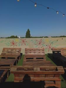 a group of wooden benches in front of a mural at Alojamiento Avellaneda in Rosario