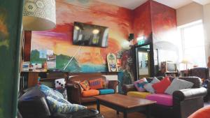 a living room with couches and a painting on the wall at High Street Hostel - Over 18s Only, Backpackers Atmosphere in Edinburgh +10 photos