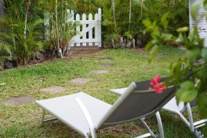 een wit hek en een stoel in een tuin bij Dodo Coconut lagon Ermitage in Saint-Gilles-les-Bains +26 foto's