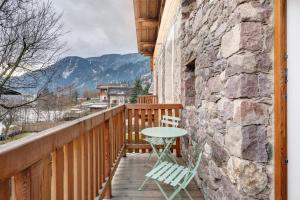 einen Holzbalkon mit einem Tisch und 2 Stühlen in der Unterkunft Alpin Chalet Samer in Sarntal