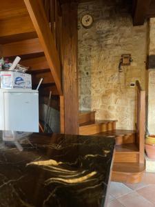 une pièce avec un mur en pierre avec une horloge sur le mur dans l'établissement Cozy maisonette de Domme, à Domme 3 autres photos