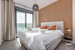 een slaapkamer met een groot bed en een groot raam bij VIVI Homes - Bonita del Sol Beach, Pool, Garden, GYM & SPA in La Cala de Mijas