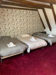 - 2 lits dans une chambre dotée d'un tapis rouge dans l'établissement Cozy maisonette de Domme, à Domme