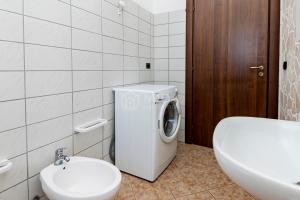 a bathroom with a washing machine and a toilet at Villa Mello in Torre Lapillo