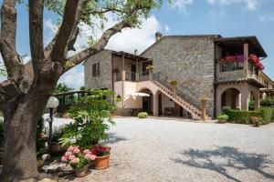 een uitzicht op een stenen huis met een boom bij Casa Vacanze Ribocchi in Campiglia Marittima
