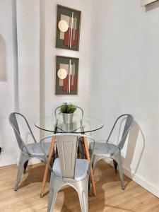 ein Glastisch und vier Stühle in einem Raum in der Unterkunft Centro Madrid Rio - Monederos C in Madrid