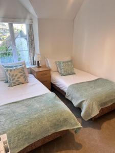 twee eenpersoonsbedden in een kamer met een raam bij Seaview Terrace - Beer in Beer