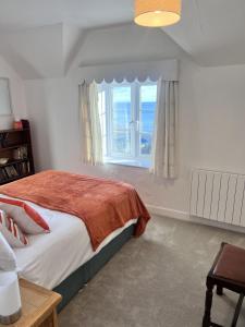 een slaapkamer met een bed en een groot raam bij Seaview Terrace - Beer in Beer