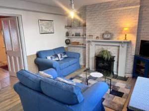 een woonkamer met twee blauwe banken en een open haard bij Seaview Terrace - Beer in Beer +5 foto's