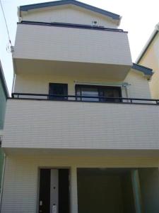 a white building with a balcony on top of it at sakuraの家 in Tokyo