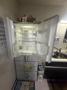 an empty refrigerator with its door open in a kitchen at sakuraの家 in Tokyo