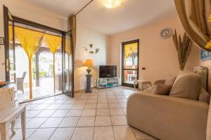 een woonkamer met een bank en een tv bij Villa Messapia in Torre dell'Orso