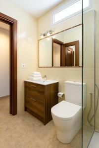 ein Badezimmer mit Toilette, Waschbecken und Spiegel in der Unterkunft Maspalomas Green Oasis 1404 in Maspalomas