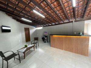 a room with chairs and a table and a counter at Pousada das Flores in Aparecida