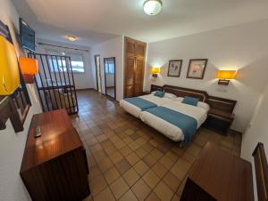 ein Schlafzimmer mit großem Bett und Holzboden in der Unterkunft Hotel Santa María in Palos de la Frontera