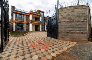 a house with a large gate and a brick driveway at Emerald Greens 3-Bedroom House in Thika