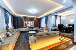 a living room with a couch and a table at Emerald Greens 3-Bedroom House in Thika