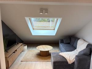 a living room with a couch and a table at Merci pour la Vue - Duplex vue lac à Malbuisson in Malbuisson