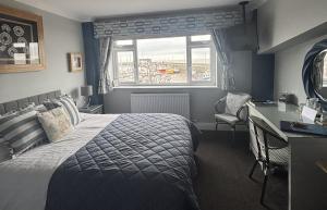 ein Schlafzimmer mit Bett, Schreibtisch und Fenster in der Unterkunft Salt on the Harbour in Bridlington