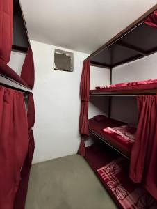 two bunk beds in a room with red curtains at Shivanand Aashray - Near Sangam in Prayagraj