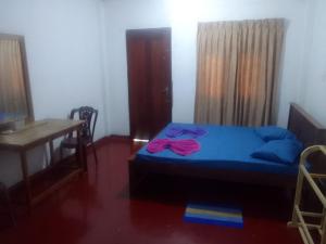 een slaapkamer met een bed, een tafel en een bureau bij Madura Resorts in Piliyandala +3 foto's