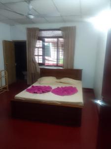 een bed met twee roze jurken erop in een kamer bij Madura Resorts in Piliyandala