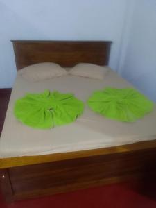 een bed met twee groene kussens erop bij Madura Resorts in Piliyandala
