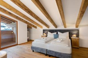 ein Schlafzimmer mit großem Bett und Holzdecken in der Unterkunft Alpin Chalet Samer in Sarntal