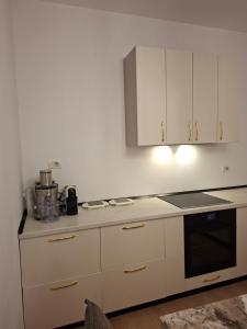 una cucina con mobili bianchi e un forno a piano cottura di Heart Apartment Tirana a Tirana