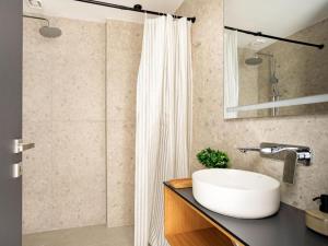 a bathroom with a white sink and a shower at Ptolemeon 20, Apts & Studios Thessaloniki Center in Thessaloniki