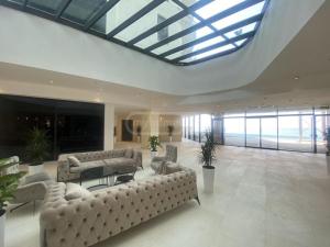 a large living room with couches and a glass ceiling at bamboo beach in Buknari