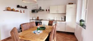 a kitchen with a wooden table and chairs in a room at Ferienwohnung am Plauer See in Alt Schwerin