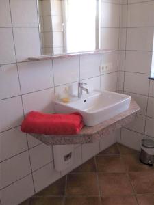 a bathroom with a sink and a red towel at Ferienwohnung am Plauer See in Alt Schwerin +9 photos